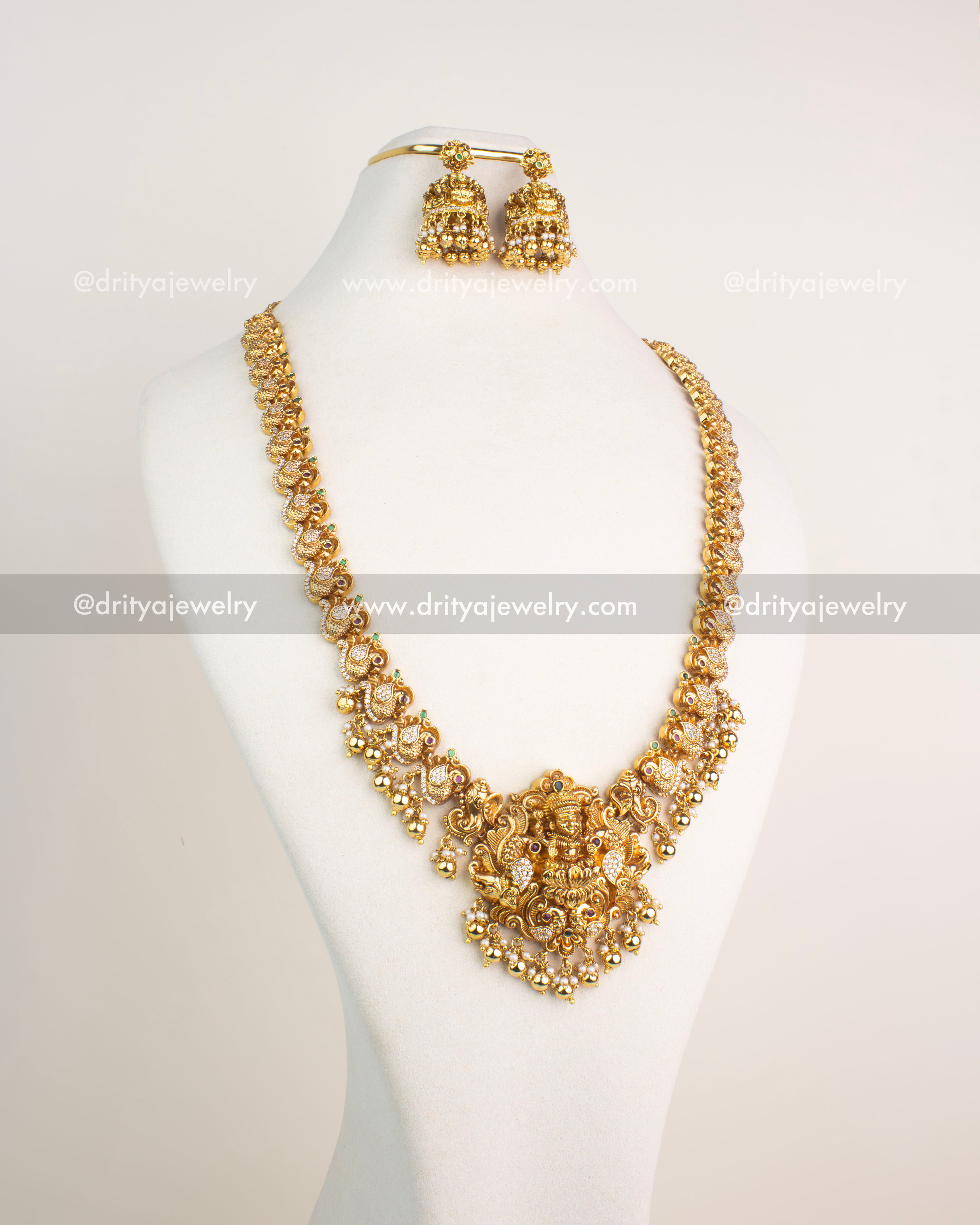 Gold-plated temple jewelry long necklace with Lakshmi pendant, pearl drops, and peacock motifs.