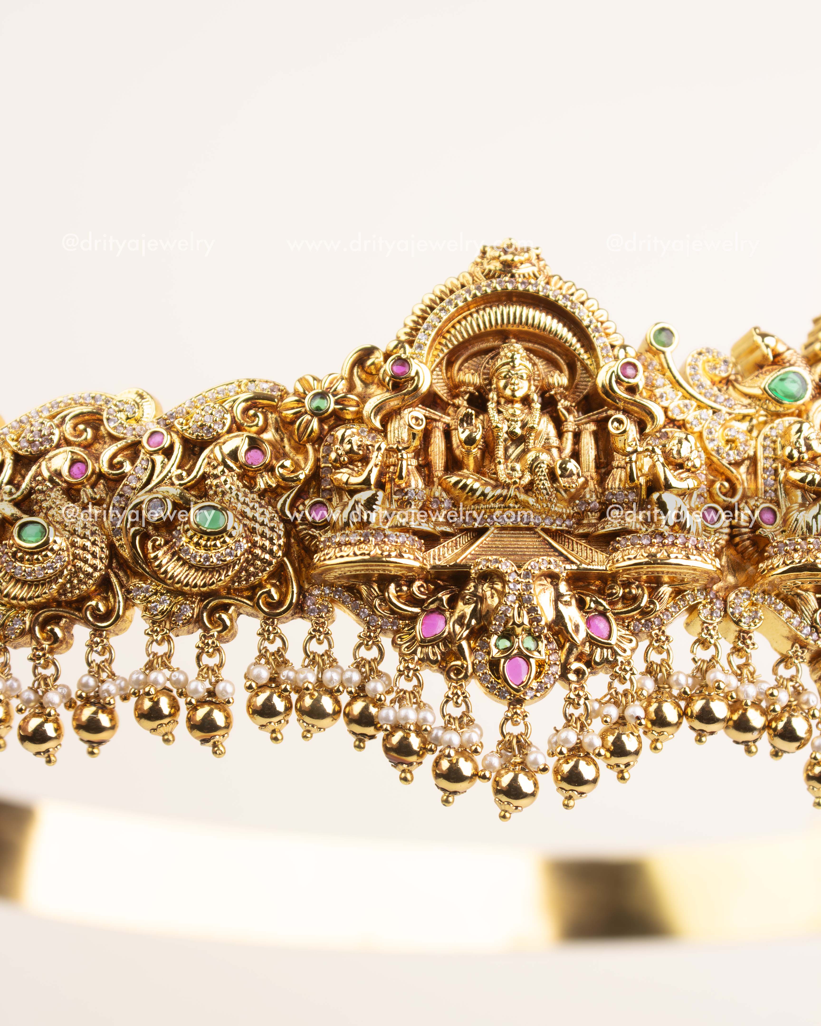 Side view showing ornate Nakshi craftsmanship, floral detailing, and hanging pearl beads.