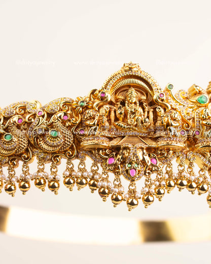 Side view showing ornate Nakshi craftsmanship, floral detailing, and hanging pearl beads.