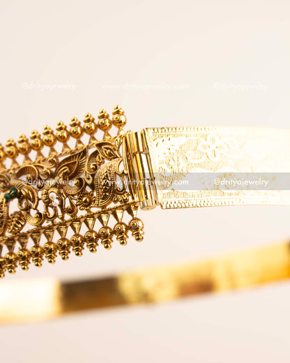 Side view showcasing intricate filigree foliage and bead edge design in antique gold polish.