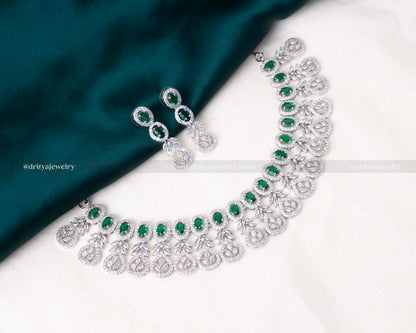 Silver-tone zircon necklace set featuring vibrant emerald stones, paired with matching earrings, ideal for weddings and festive occasions.