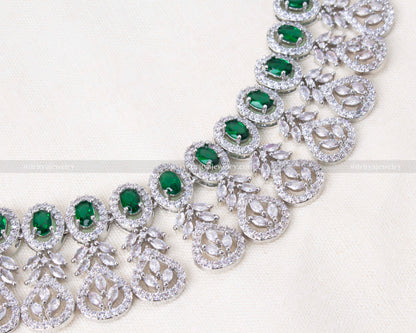 Silver-tone zircon necklace set featuring vibrant emerald stones, paired with matching earrings, ideal for weddings and festive occasions.