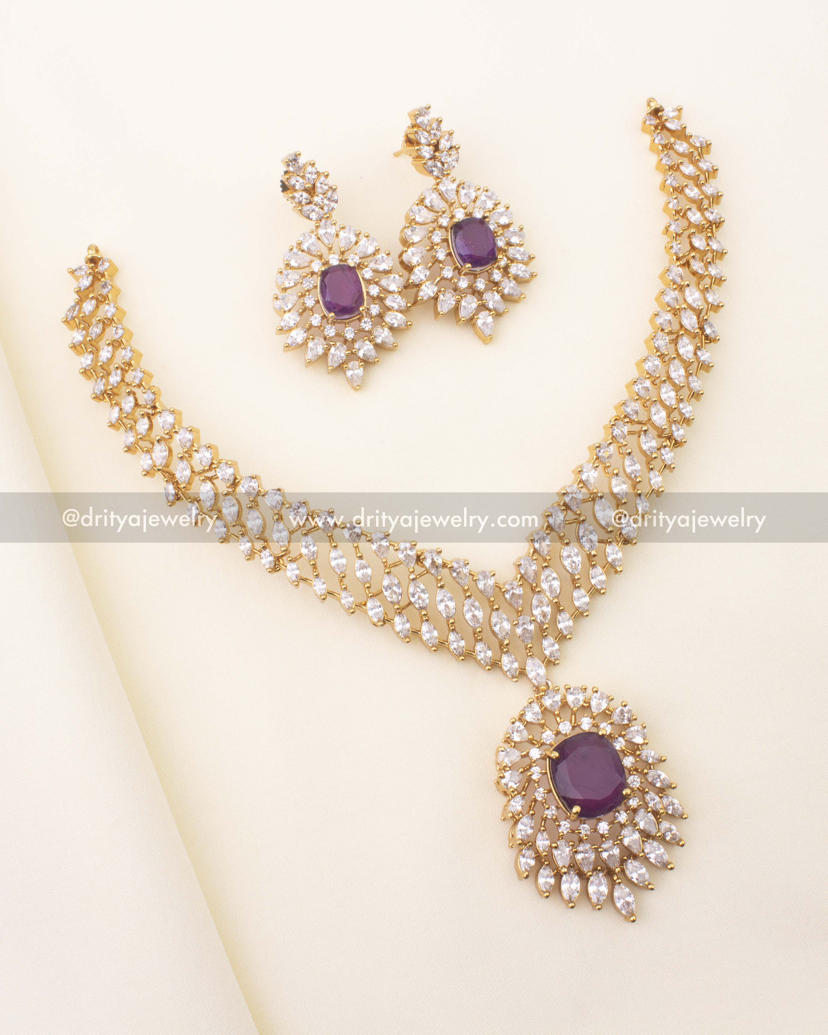 Gold‑plated short necklace with royal‑purple centerpiece and CZ halo, paired with matching earrings.