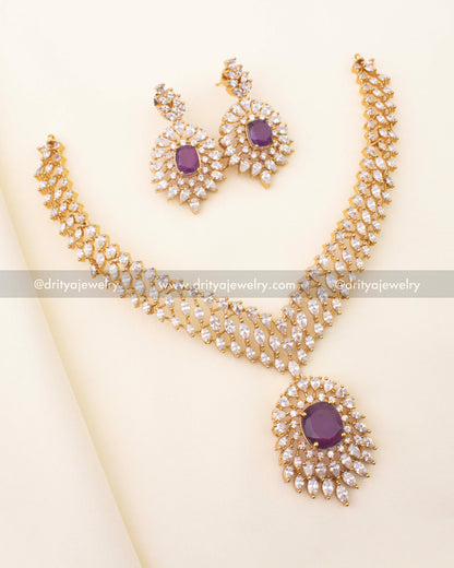 Gold‑plated short necklace with royal‑purple centerpiece and CZ halo, paired with matching earrings.