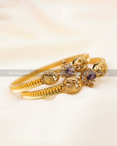 Antique gold bangles featuring purple CZ center and peacock detail.