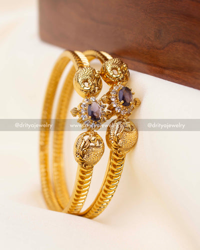 Antique gold bangles featuring purple CZ center and peacock detail.