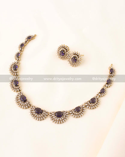 Elegant gold-toned short necklace set with deep purple stones and CZ studded floral design.