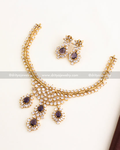 Floral gold necklace set with deep purple stones and diamond-like CZ work.