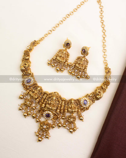 Premium nakshi necklace with Goddess motifs, purple bead drops, and antique gold finish.