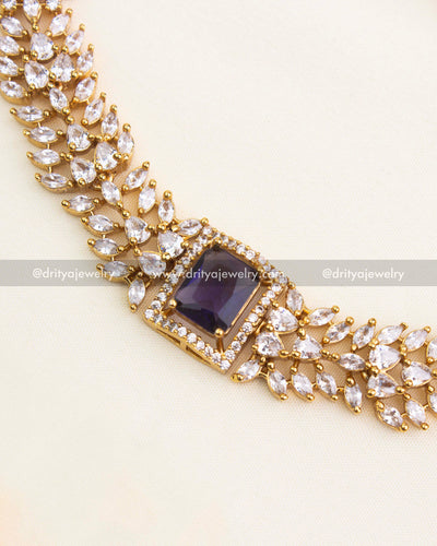 Close-up of royal purple stone bordered by micro CZs in a floral-inspired necklace design.
