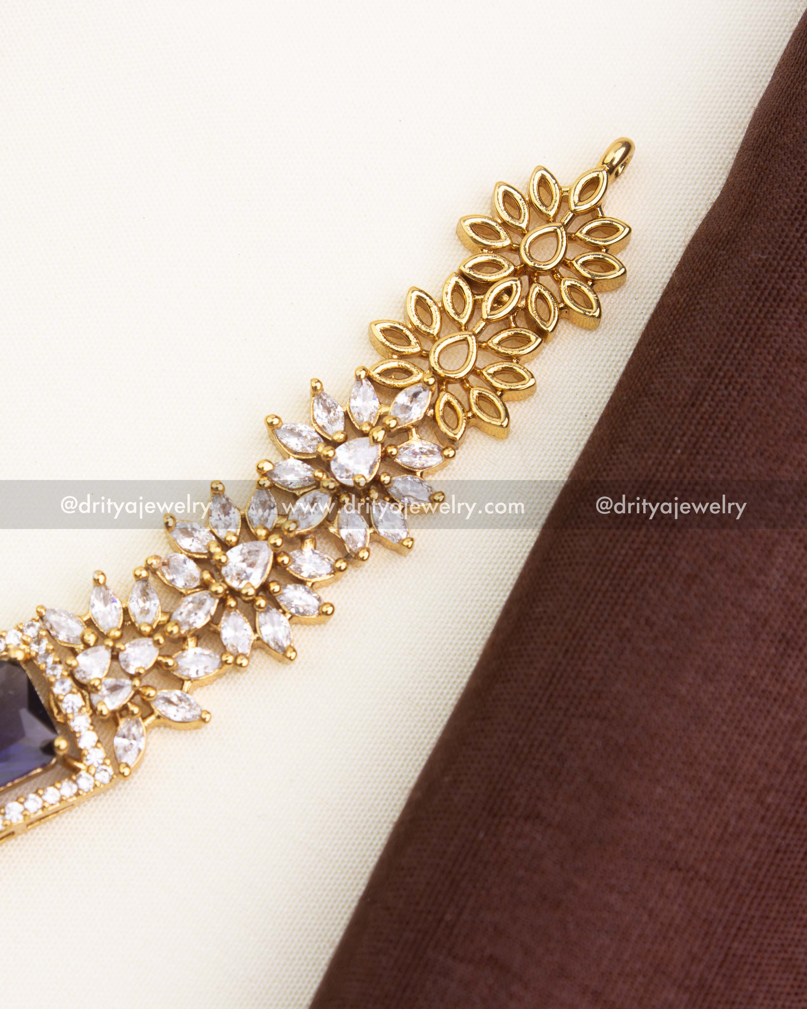 Close-up of royal purple stone bordered by micro CZs in a floral-inspired necklace design.