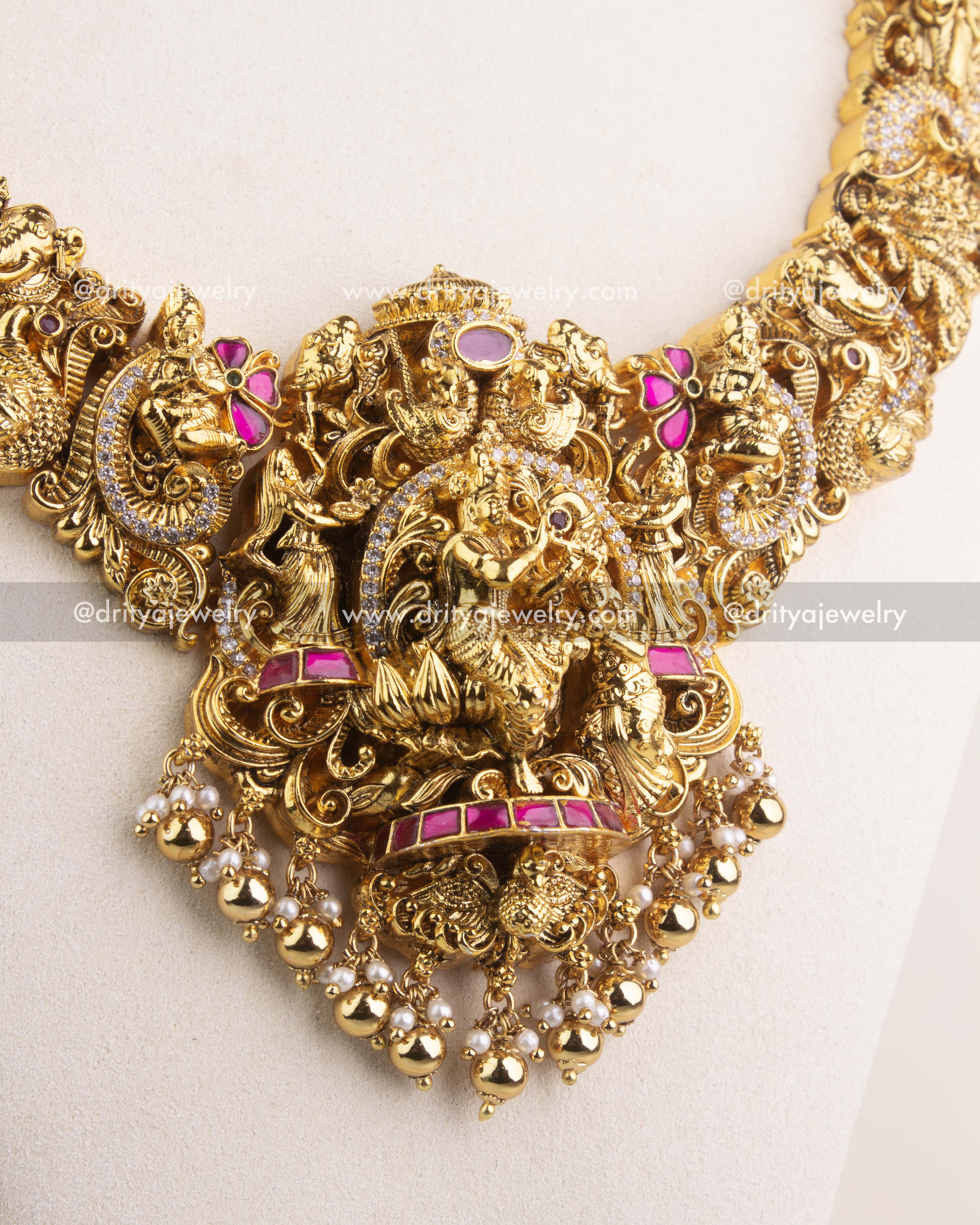 Close-up of Radha Krishna pendant with kemp stones and intricate Nakshi temple jewelry detailing.