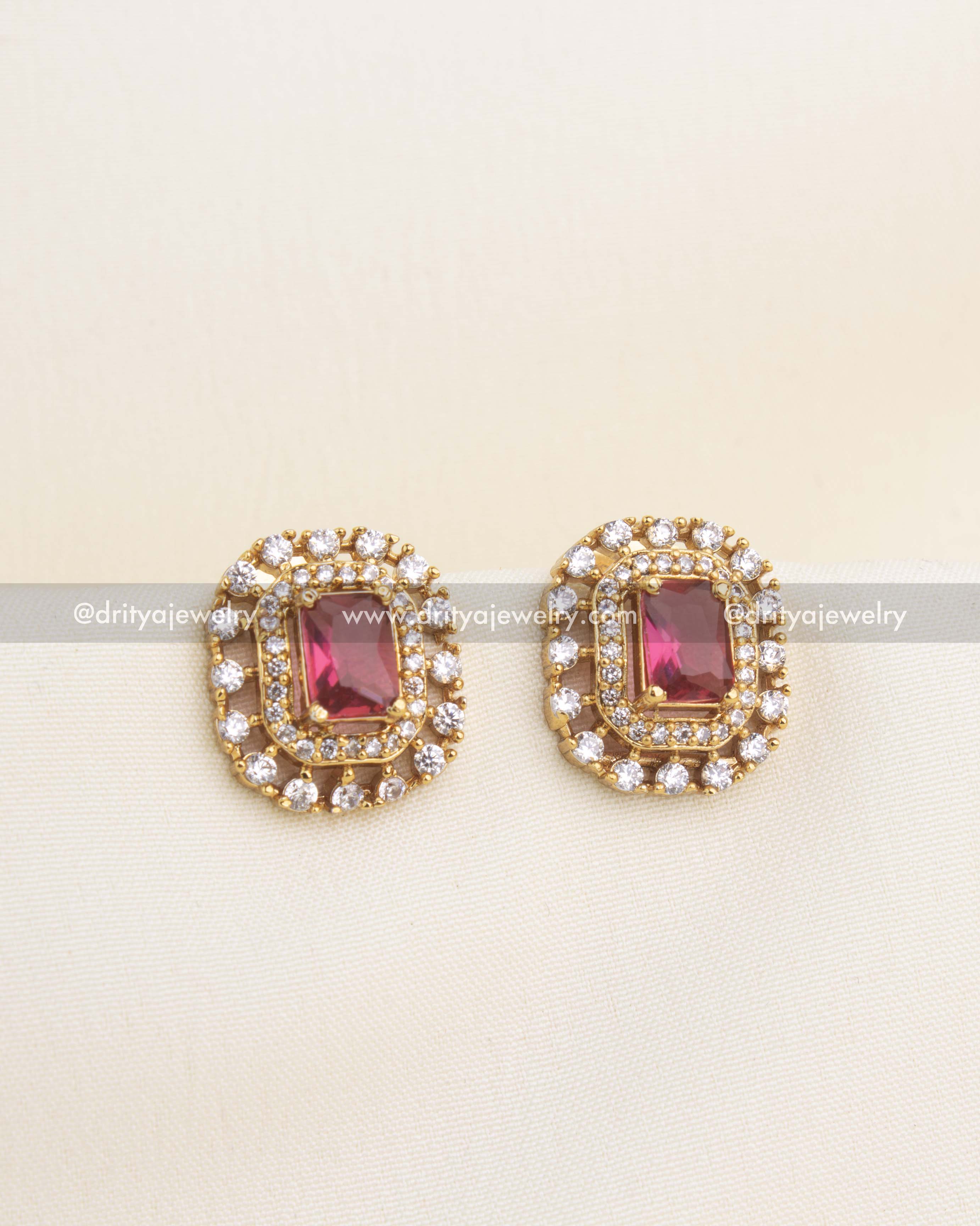 Elegant red CZ stud earrings with ruby-inspired center stone and double-layered CZ diamond halo.