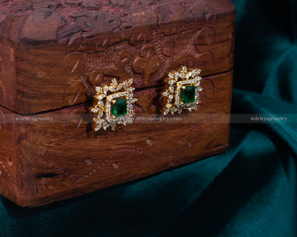 Elegant gold-tone stud earrings with a faux emerald center and sparkling cubic zirconia halo, perfect for adding a touch of luxury to any attire.