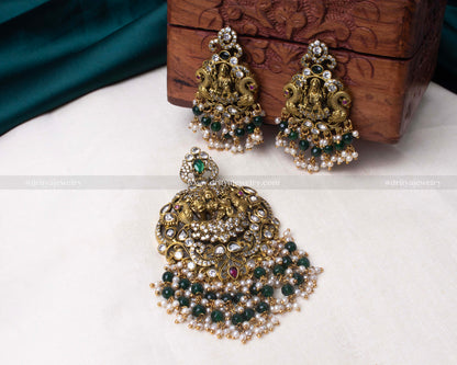 A beautifully crafted Lakshmi Devi pendant set with green beads and pearls, paired with matching earrings.