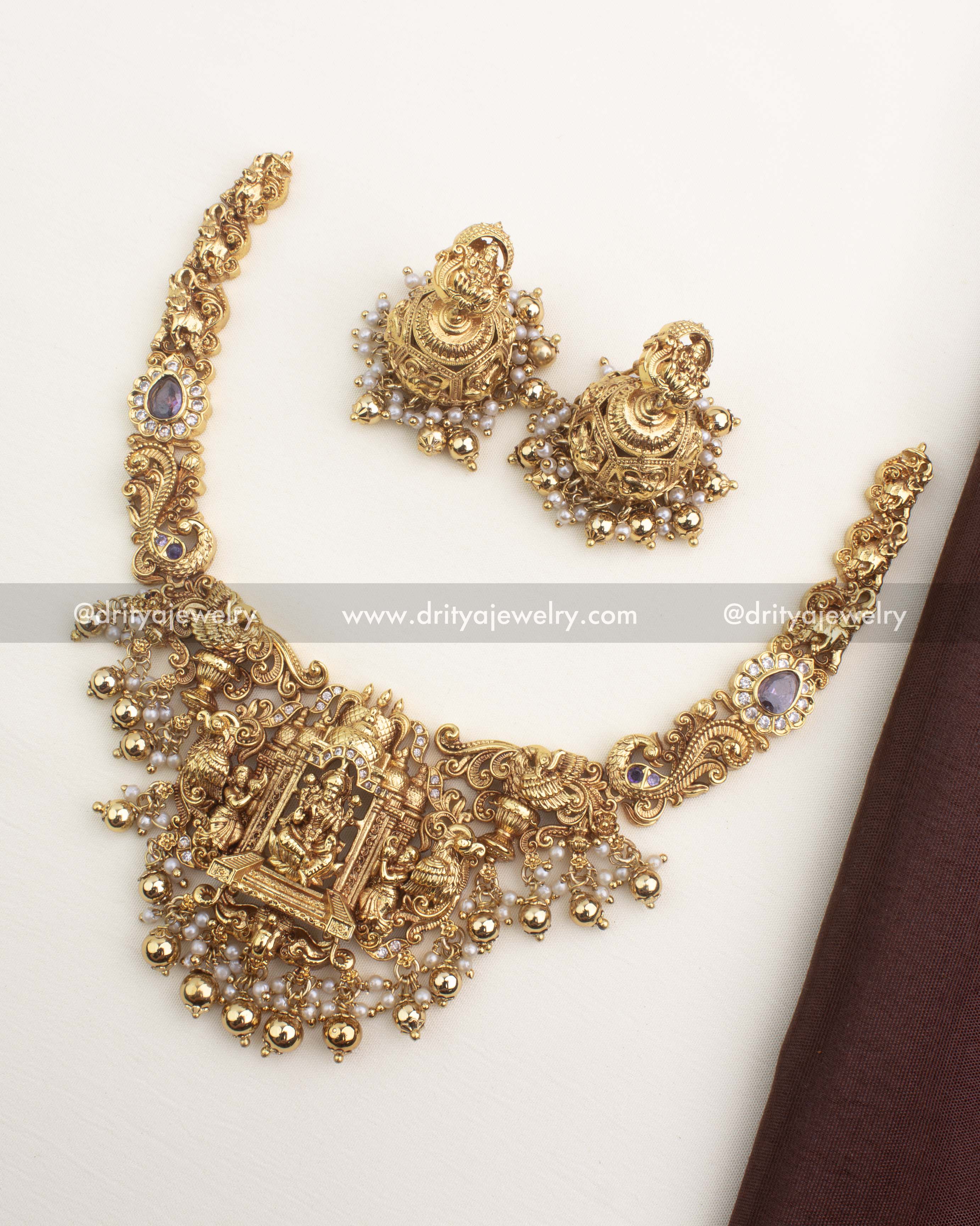 Temple-style short necklace with Lakshmi motif, antique gold finish, and matching jhumkas from Dritya Jewelry.