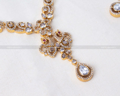 Elegant peacock motif necklace set in gold with sparkling reverse AD stones, ideal for weddings and formal occasions.