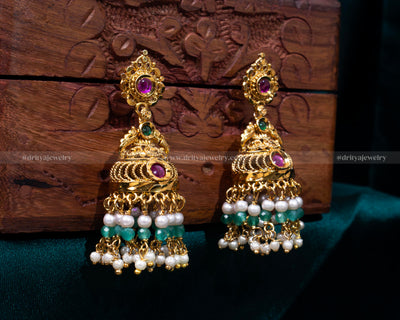 Elegant gold-plated Jhumka earrings with synthetic ruby and emerald gemstones, accented with cascading pearls, perfect for weddings and formal events.