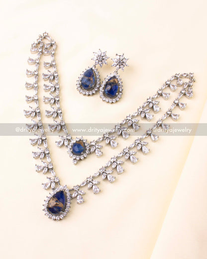 Silver-toned dual-layer necklace set with teardrop blue stone pendant and CZ embellishments.