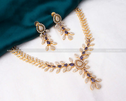 Elegant gold necklace set with purple and clear cubic zirconia stones, perfect for weddings and formal events.