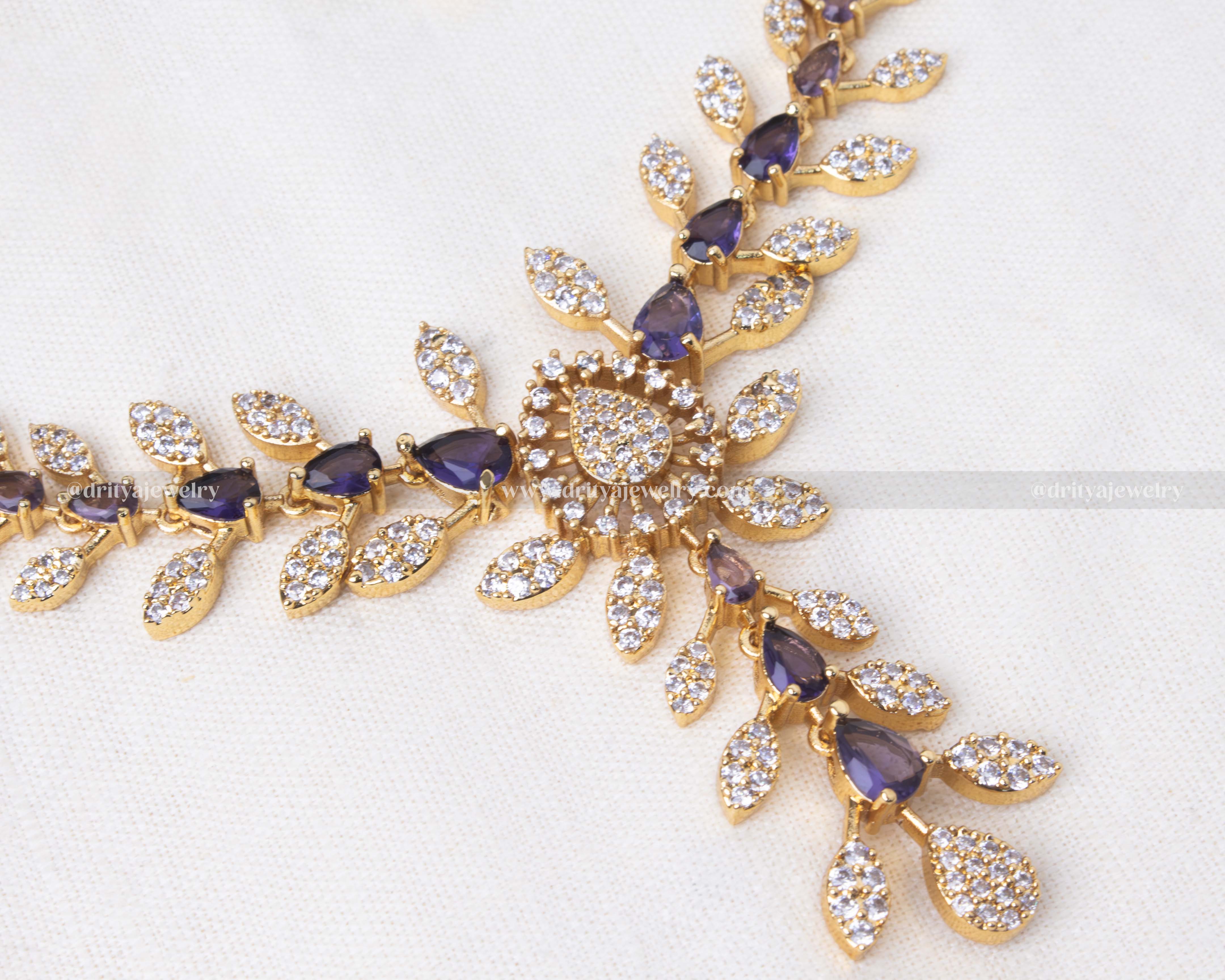 Elegant gold necklace set with purple and clear cubic zirconia stones, perfect for weddings and formal events.