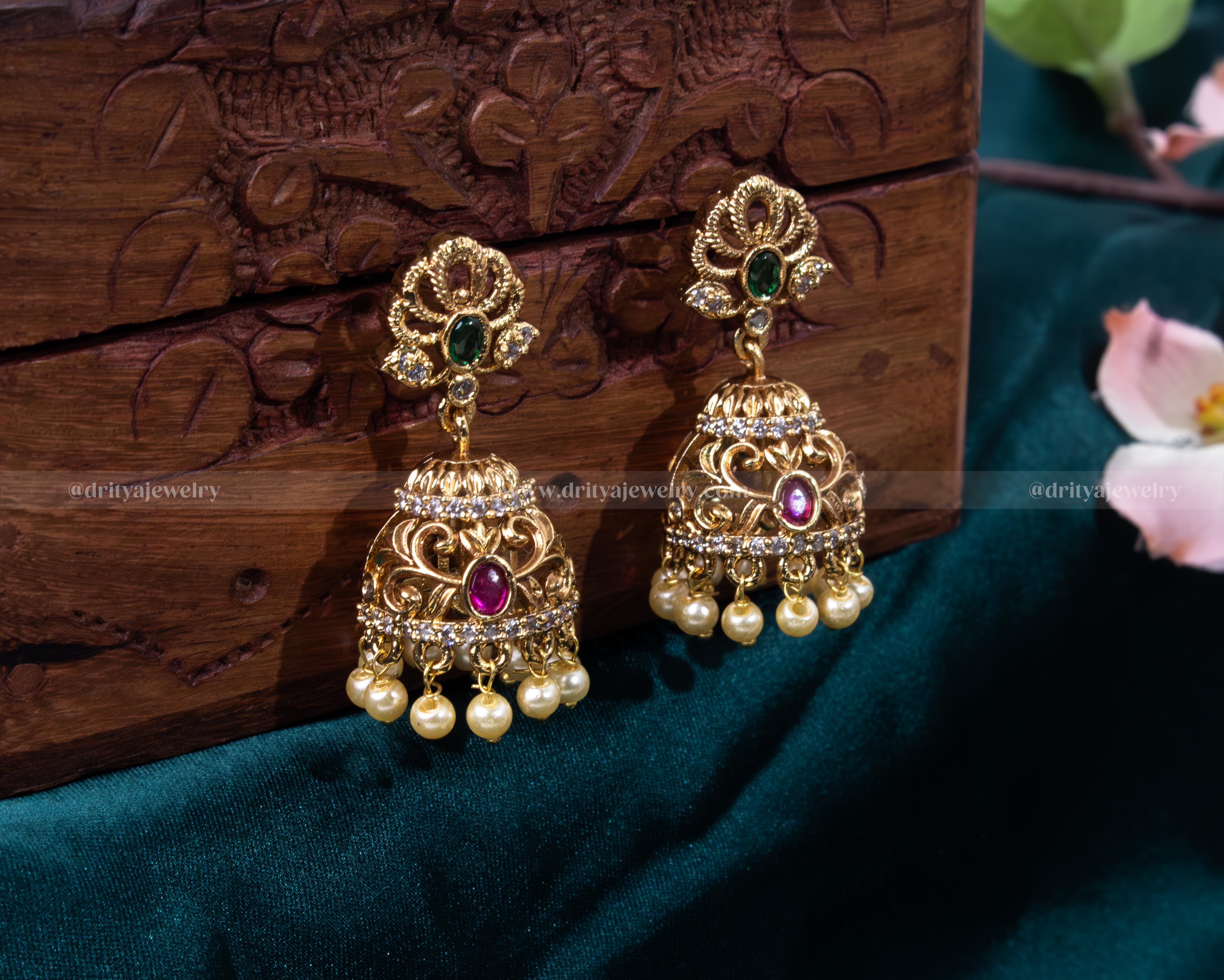 Detailed view of Royal Temple Earrings featuring intricate carvings with emerald and ruby accents, and pearl drops by Dritya Jewelry.