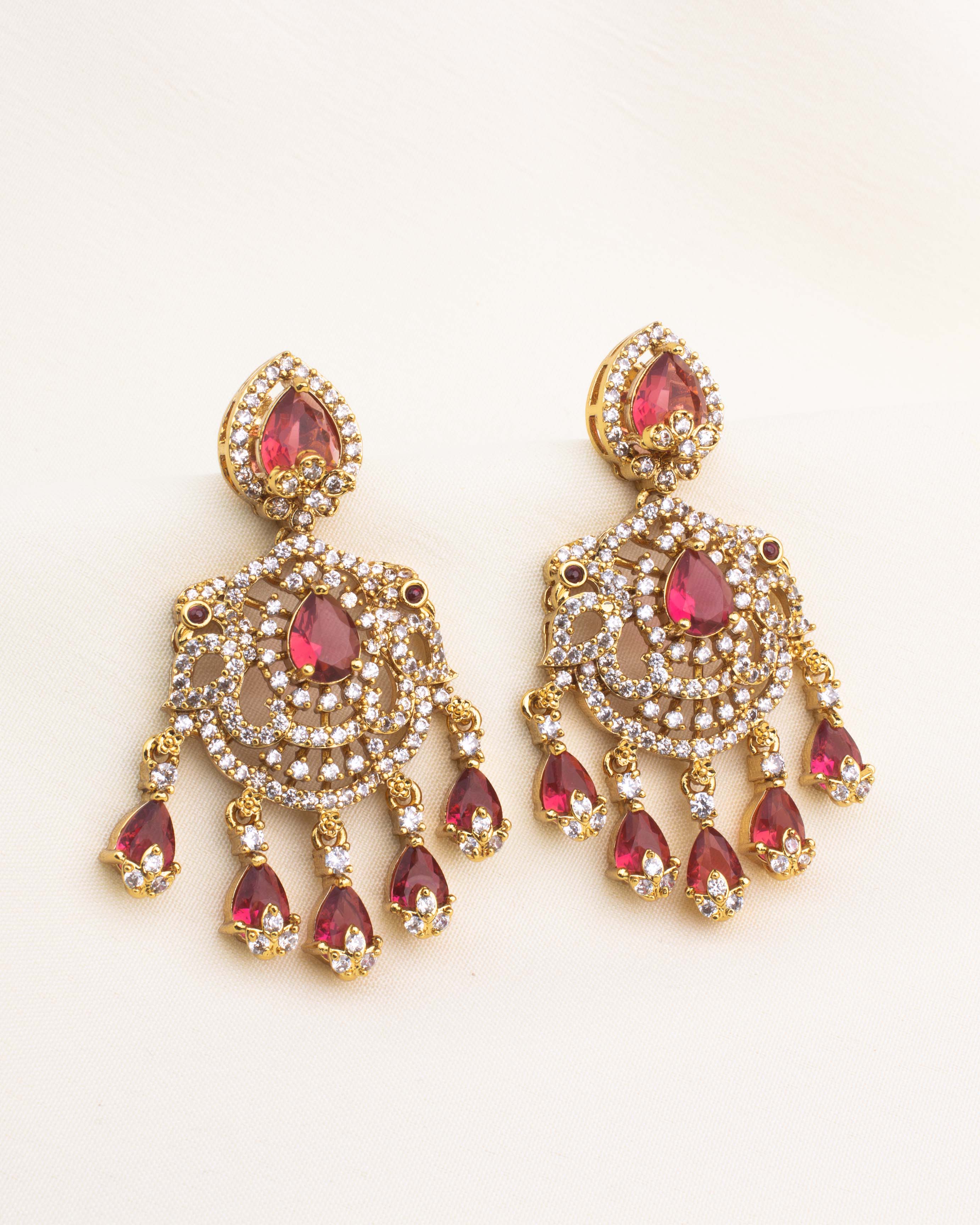 Ruby red chandelier earrings with CZ setting and teardrop design in gold-plated finish.