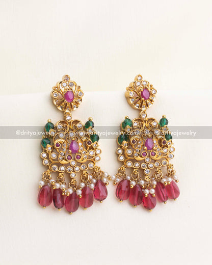 Ruby teardrop bead chandbali earrings with gold-plated AD studded motifs.