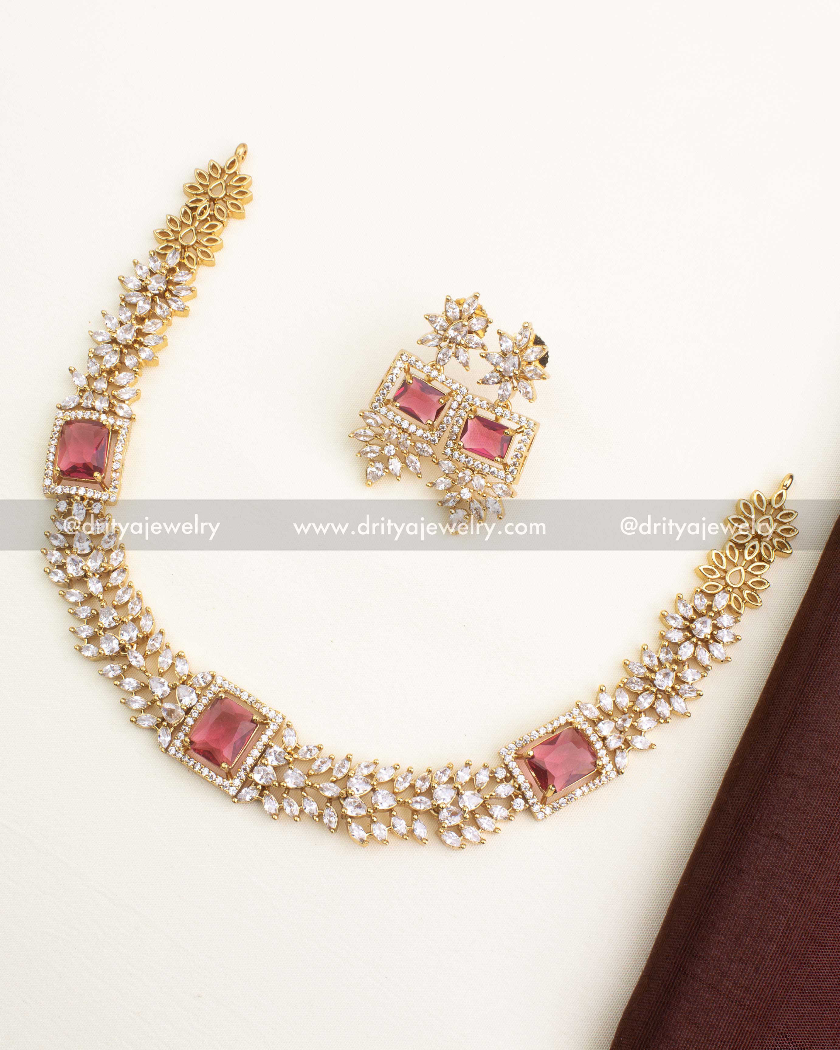 Short necklace set featuring ruby red square stone centerpiece and CZ floral chain links with matching earrings.