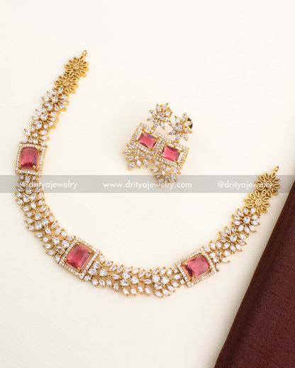 Short necklace set featuring ruby red square stone centerpiece and CZ floral chain links with matching earrings.