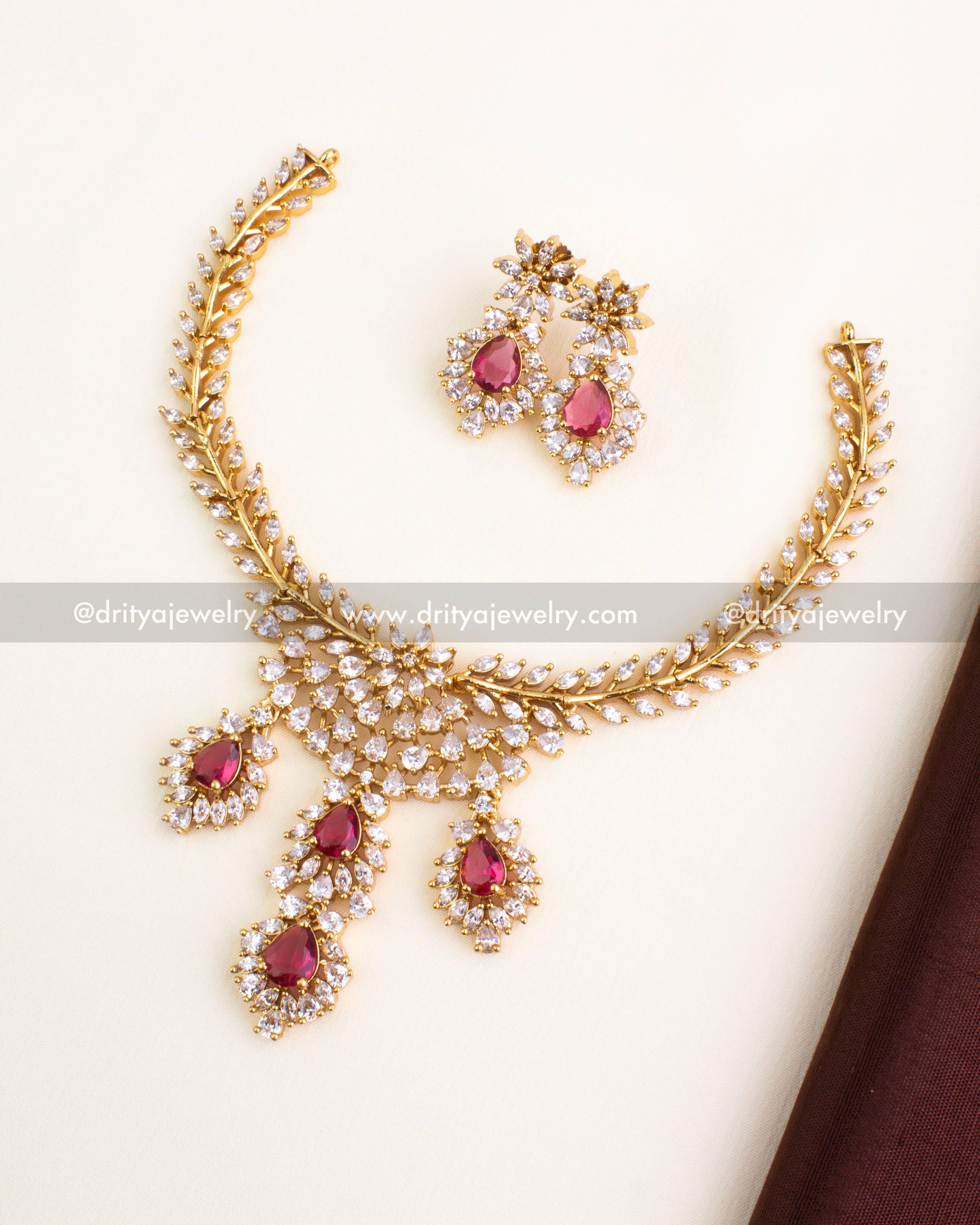 Short necklace set with red stones, CZ border, and floral gold finish.
