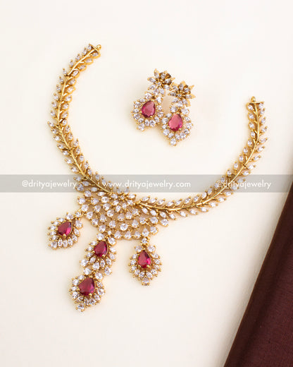 Short necklace set with red stones, CZ border, and floral gold finish.