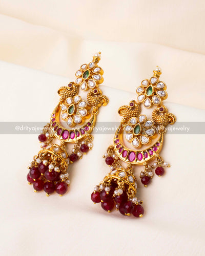 Traditional ruby red kemp Jhumka earrings with gold polish, kundan detailing, and pearl bead drops.