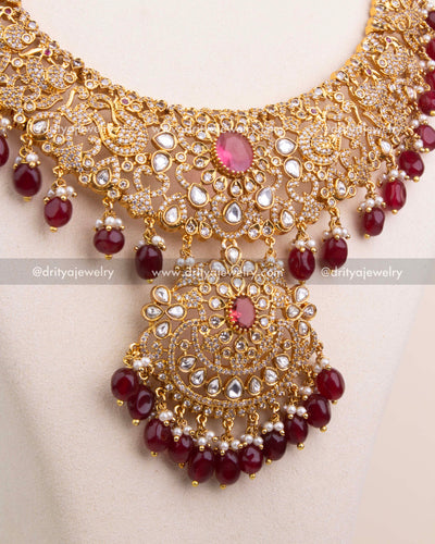 Intricately designed pendant with kundan work, red centerpiece stone, and bead fringe.