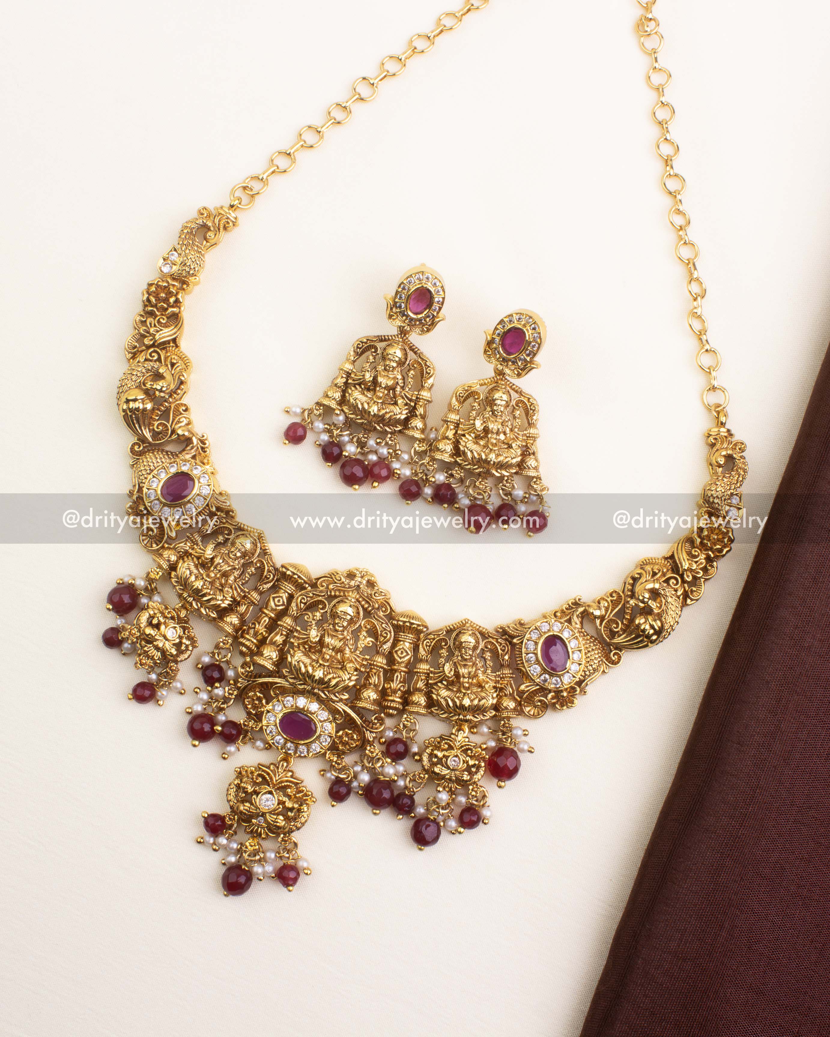 Traditional nakshi short necklace with Goddess motifs, ruby beads, and antique gold finish.