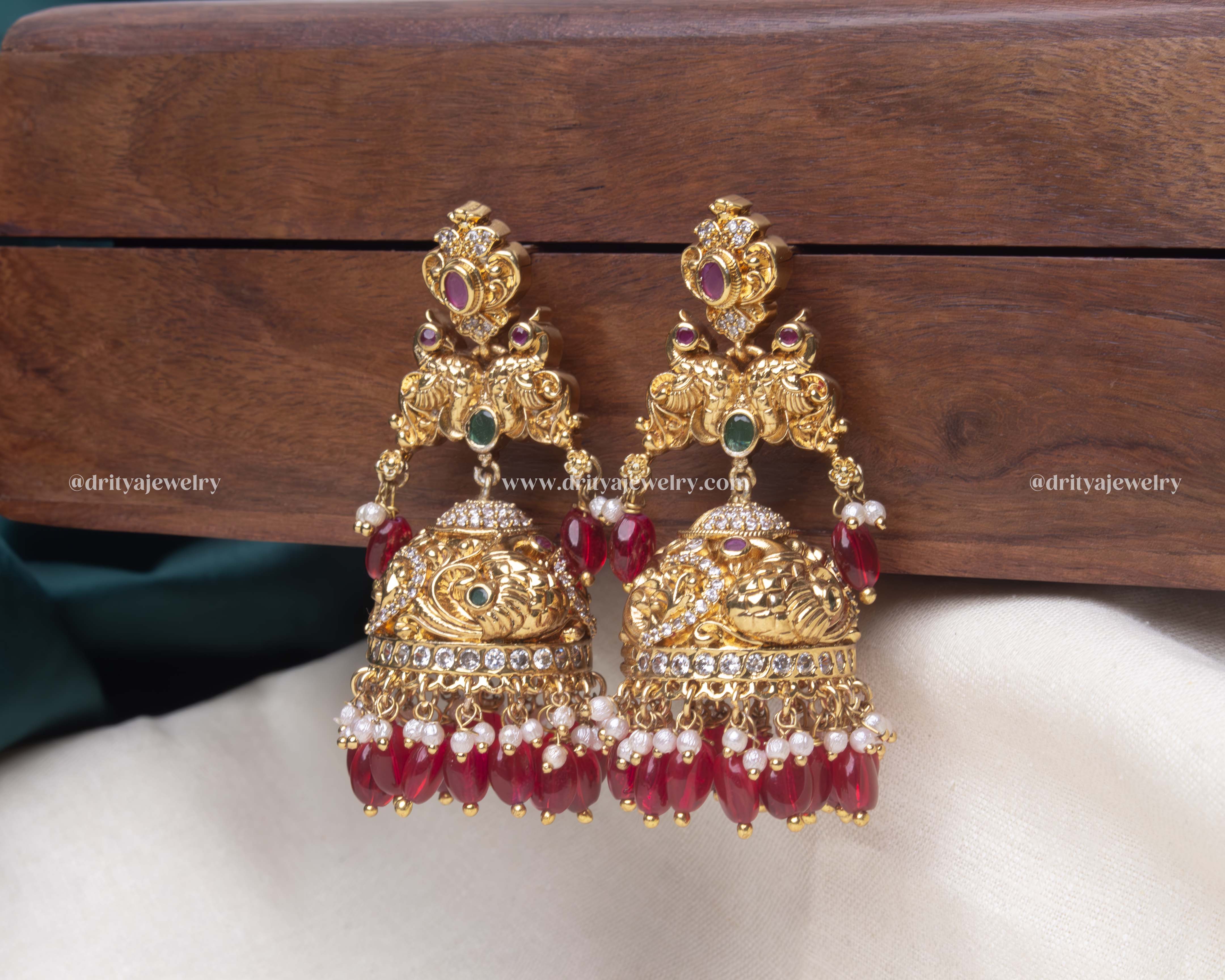 Detailed view of the ruby red Radiant Gemstone Jhumka Earrings, showcasing the vibrant gemstones and elegant pearl finish.