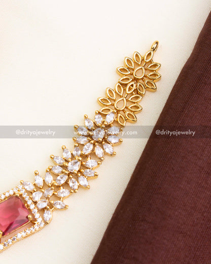 Detailed close-up of ruby red centerpiece surrounded by micro CZ stones.