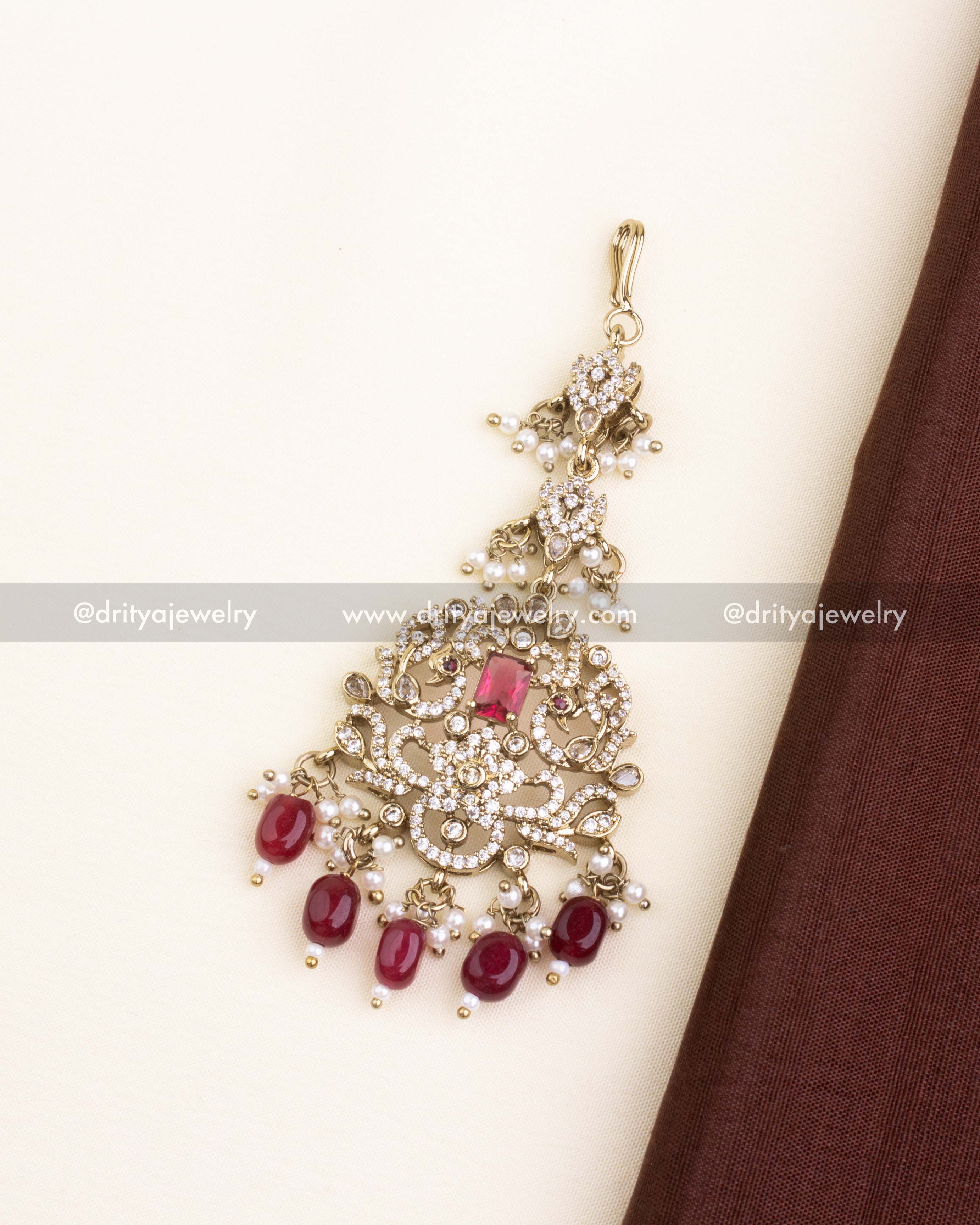 Victorian style maang tikka with ruby red stones, pearls, and CZ detailing.