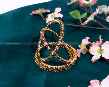 Ruby Bangle Set by Dritya Jewelry, featuring deep red rubies complemented by a luxurious gold setting.