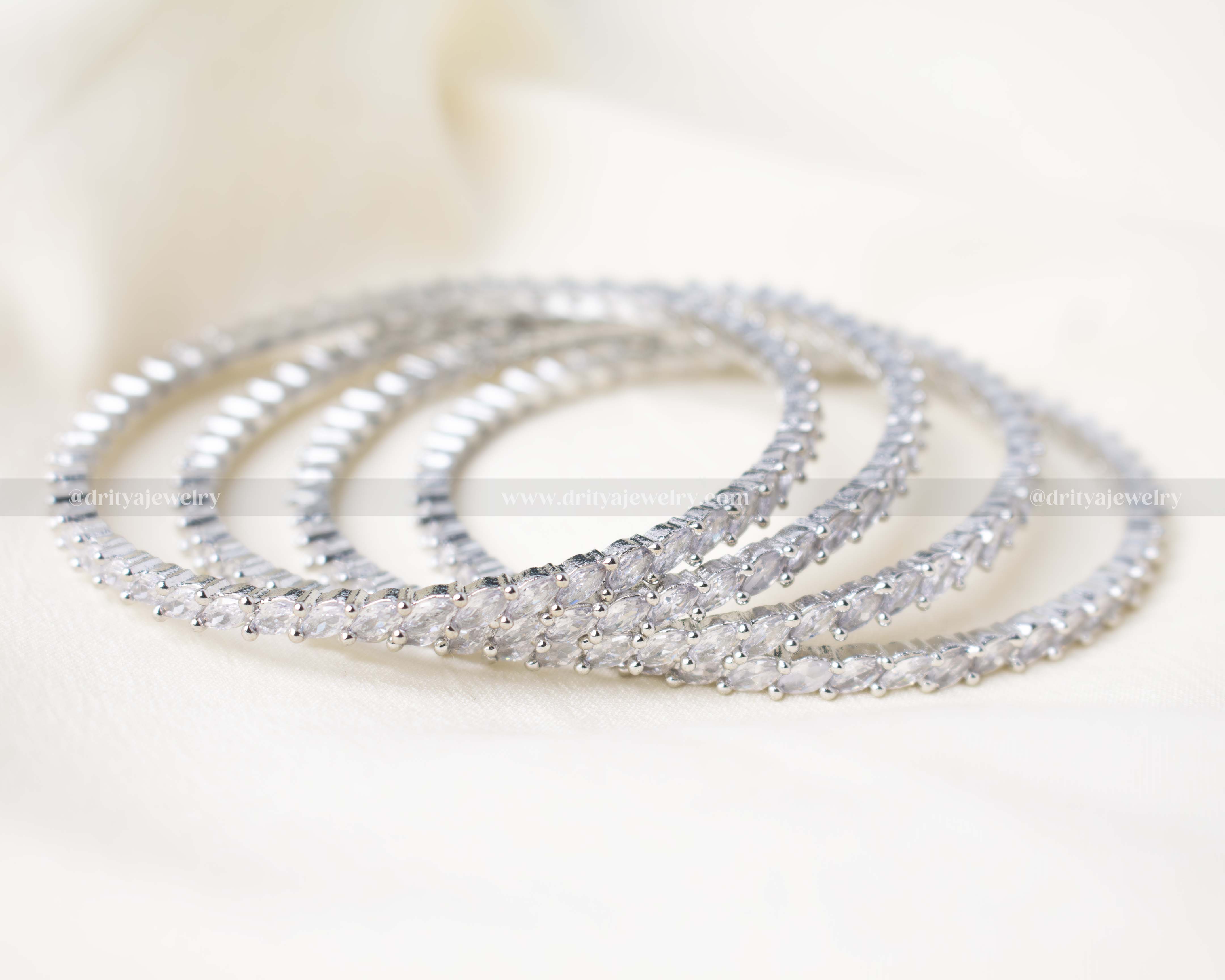 Set of 4 elegant zircon bangles with silver polish and sparkling stones, perfect for weddings and festive occasions.