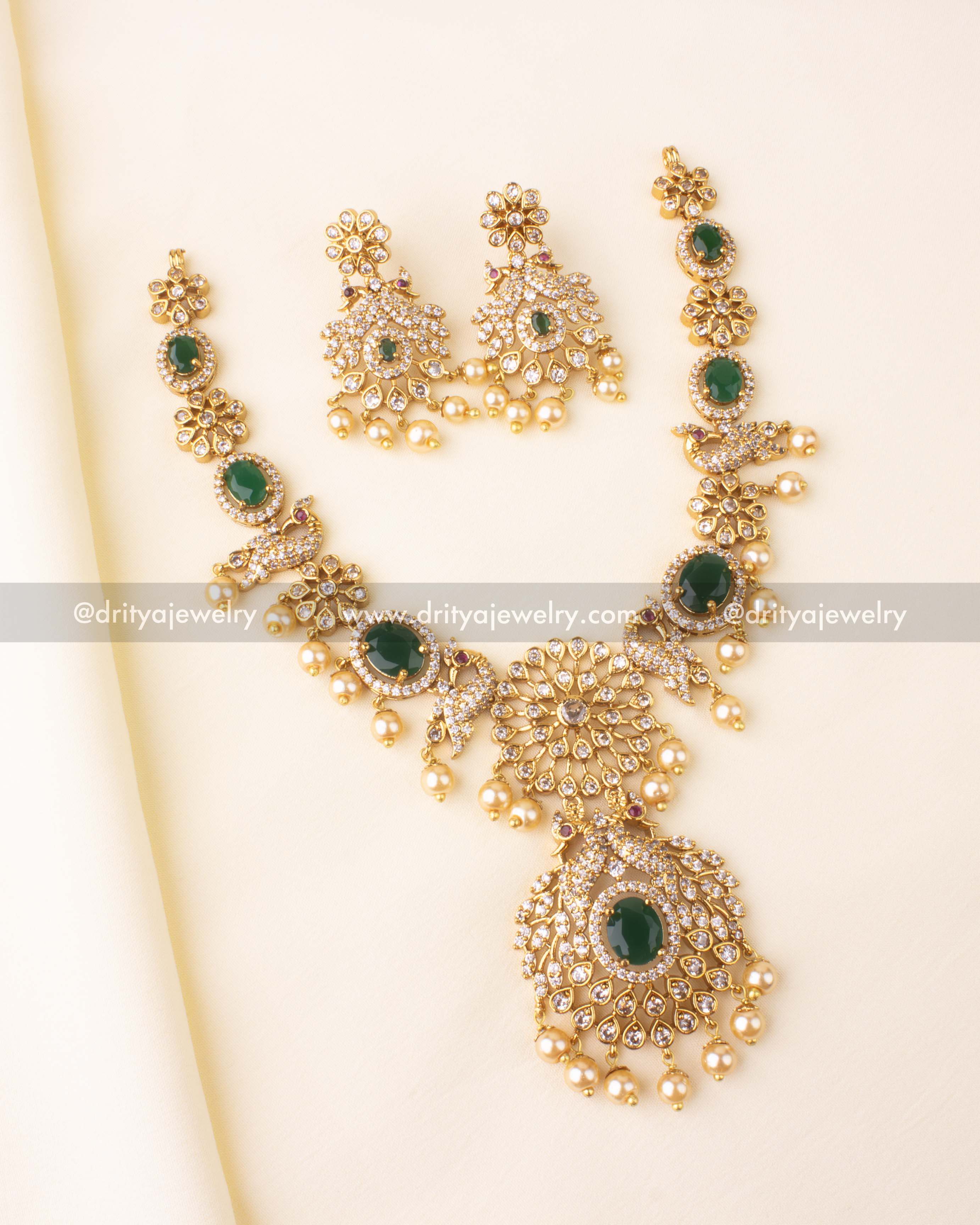 Premium short necklace set with green center stones, floral CZ patterns, and pearl drops.