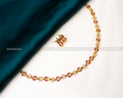 Stylish short necklace set featuring pink AD stones and a gold-tone finish.