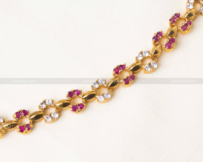 Stylish short necklace set featuring pink AD stones and a gold-tone finish.