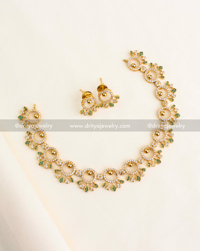 Elegant short necklace set with circular CZ motifs and green accents, gold polish.