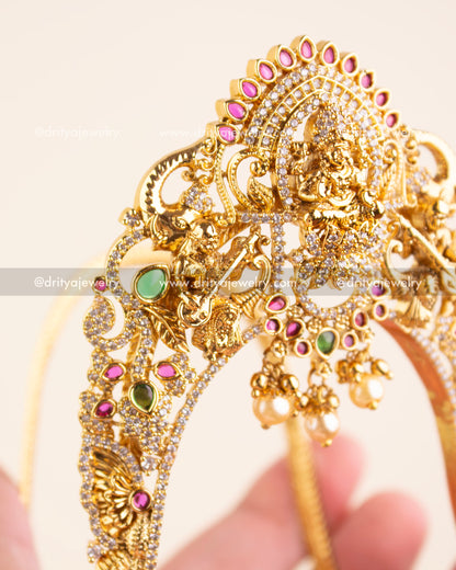 Intricate temple design armlet featuring Goddess Lakshmi, musicians, and pearl drops.