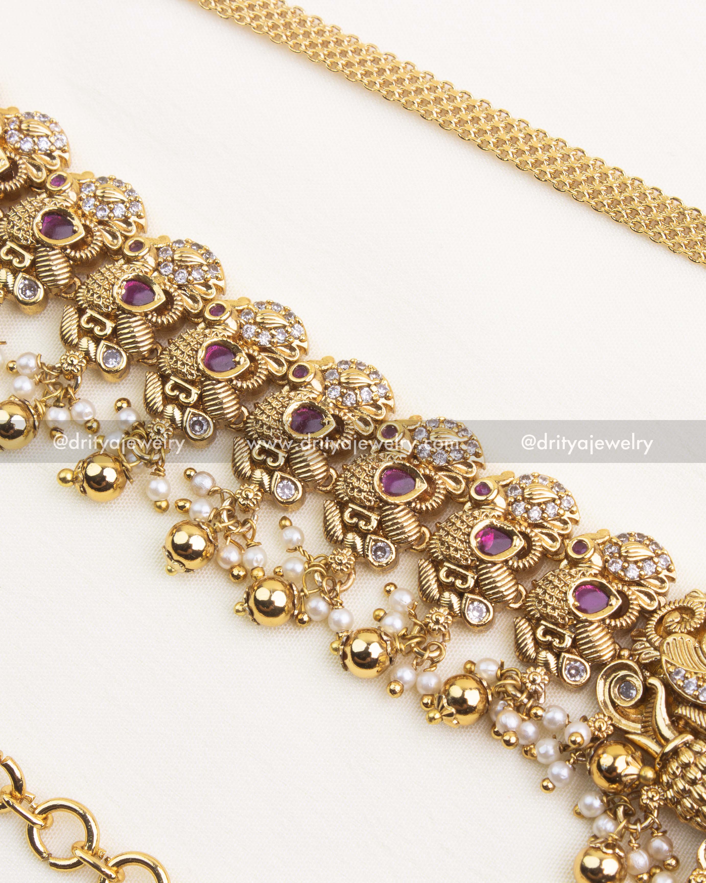 Detailed side close up of Nakshi hip chain showing ruby red stones, pearl beads, and antique motifs.
