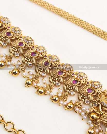 Detailed side close up of Nakshi hip chain showing ruby red stones, pearl beads, and antique motifs.