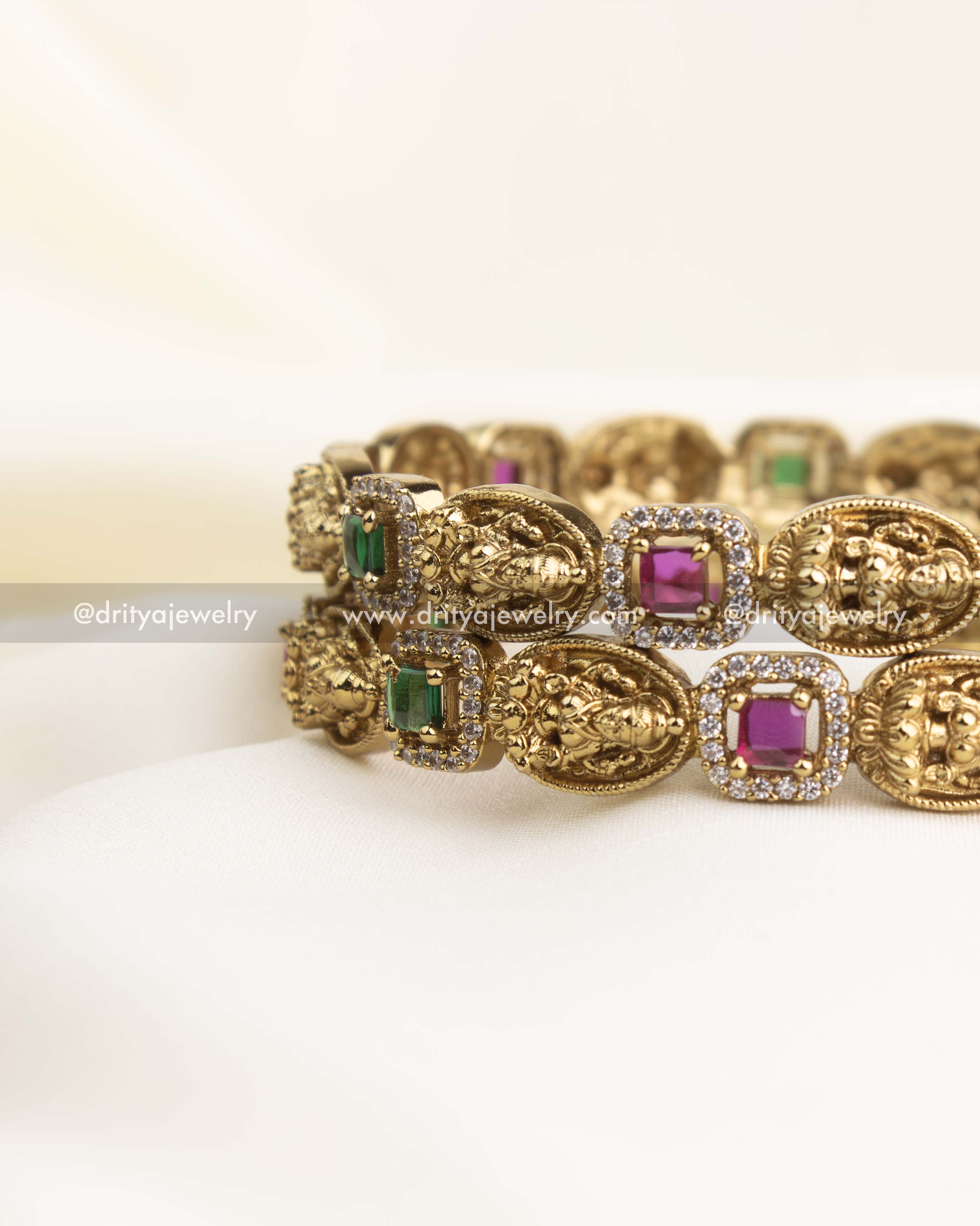 Side view showing linked square bezels in green and ruby with antique high-gold finish.