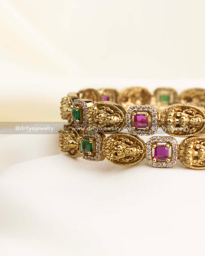 Side view showing linked square bezels in green and ruby with antique high-gold finish.