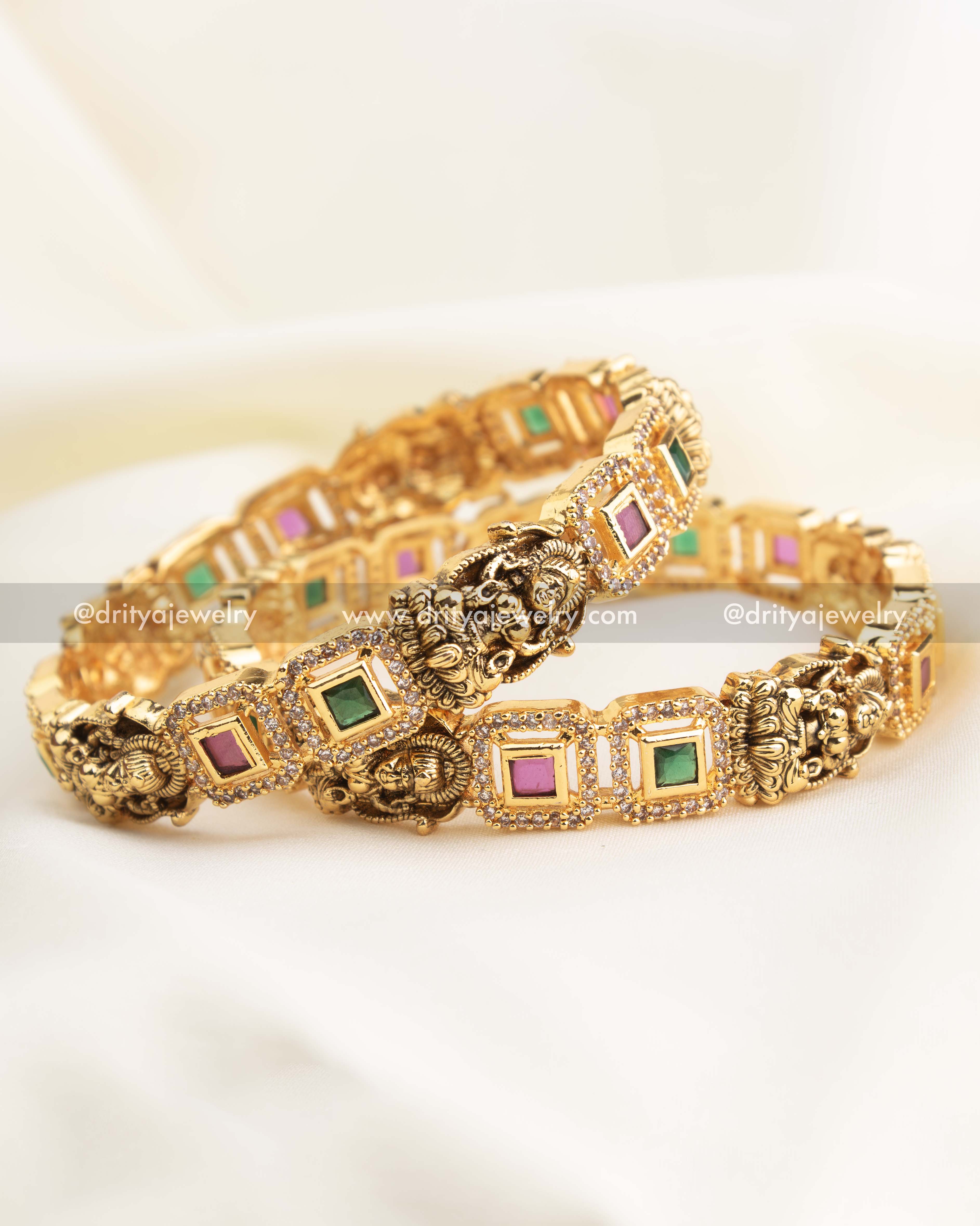 Side view of Nakshi carved Lakshmi motifs on high-gold temple bangles.